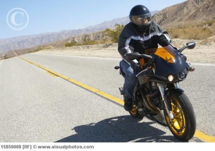 man_riding_motorcycle_on_desert_road_15850008.jpg